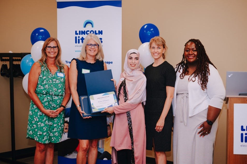Lincoln Littles staff and Lincoln Mayor posing with a childcare teacher graduate